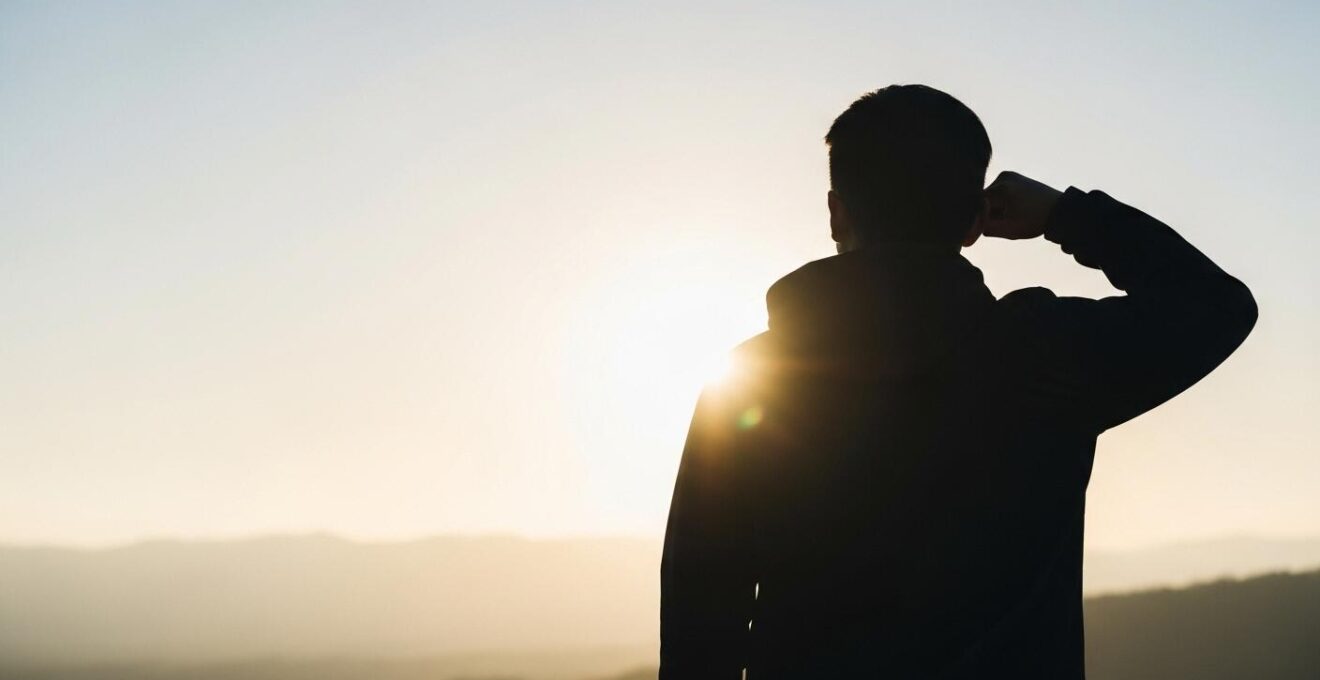 Une personne heureuse et motivée regardant un horizon lumineux symbolisant la transformation de la passion en métier
